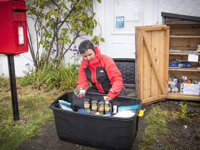 Becs Barker checks the donations left in the "swap shop" box in Minard, Argyll and Bute.