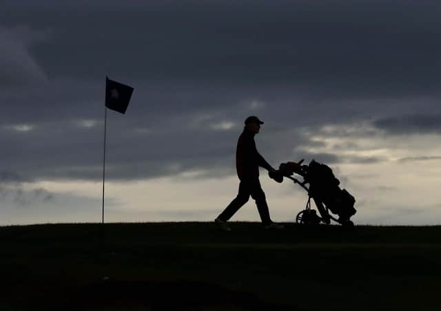Golfers walk past the first green at Charlesland Golf Club in Greystones, County Wicklow, as phase one of Ireland's five phase exit plan was triggered on Monday.