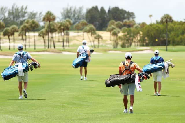 Rory McIlroy, Dustin Johnson, Rickie Fowler and Matthew Wolff carry their own bags as they walk down the first fairway. Picture: Getty.