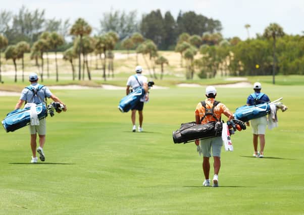 Rory McIlroy, Dustin Johnson, Rickie Fowler and Matthew Wolff carry their own bags as they walk down the first fairway. Picture: Getty.