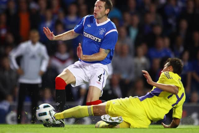 GLASGOW, SCOTLAND - AUGUST 25: Kirk Broadfoot of Rangers FC is tackled by Arghus of NK Maribor during the UEFA Europa League play-off second leg match between Rangers FC and NK Maribor at Ibrox Stadium on August 25, 2011 in Glasgow, Scotland. (Photo by Jeff J Mitchell/Getty Images)