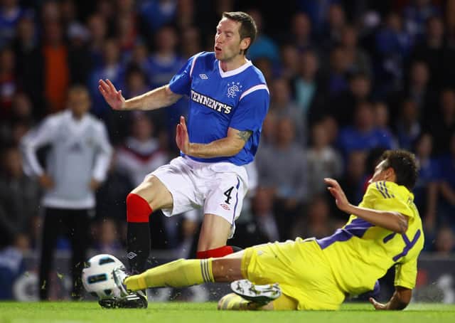GLASGOW, SCOTLAND - AUGUST 25: Kirk Broadfoot of Rangers FC is tackled by Arghus of NK Maribor during the UEFA Europa League play-off second leg match between Rangers FC and NK Maribor at Ibrox Stadium on August 25, 2011 in Glasgow, Scotland. (Photo by Jeff J Mitchell/Getty Images)