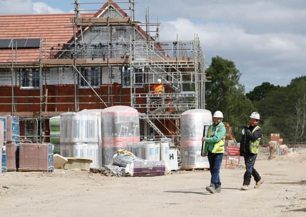 Workers carry a pane of glass on a construction site near Guildford, south-west of London. Picture: Adrian Dennis/AFP via Getty Images