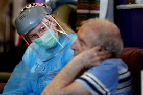 A nurse in PPE speaks to a care home resident (Picture: Frank Augstein/AP)