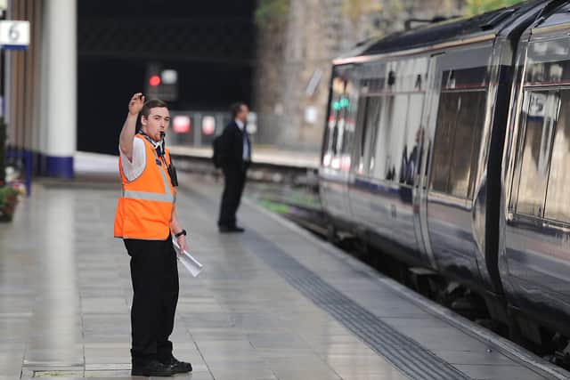 A conductor blows a whistle at Queen Street Station. Picture: John Devlin