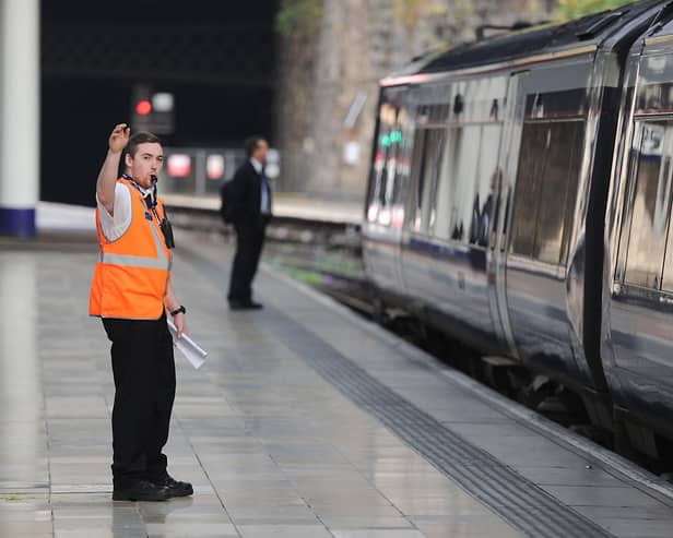 A conductor blows a whistle at Queen Street Station. Picture: John Devlin