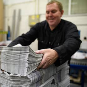 BARNSLEY, ENGLAND - SEPTEMBER 20: A member of the packing team stacks copies of the weekly newspaper as the latest edition is printed at the Barnsley Chronicle press during a nightshift on September 20, 2018 in Barnsley, England. The latest newspaper circulation figures, covering 2017, listed a readership of 19,855 copies per week. Launched in 1858, the Barnsley Chronicle is one of the last privately-owned weekly newspapers in the country, producing each copy in house with their own journalists, design team and full printing press. Owned and operated by the Hewitt family since 1923, it is the largest circulating weekly newspaper in Yorkshire, with profits boosted by off-shoot companies such as military history publishers Pen and Sword and go-kart company Tyke Racing, operating under the Acredula Group. (Photo by Leon Neal/Getty Images)