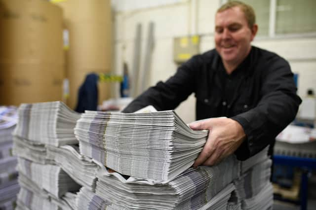 BARNSLEY, ENGLAND - SEPTEMBER 20: A member of the packing team stacks copies of the weekly newspaper as the latest edition is printed at the Barnsley Chronicle press during a nightshift on September 20, 2018 in Barnsley, England. The latest newspaper circulation figures, covering 2017, listed a readership of 19,855 copies per week. Launched in 1858, the Barnsley Chronicle is one of the last privately-owned weekly newspapers in the country, producing each copy in house with their own journalists, design team and full printing press. Owned and operated by the Hewitt family since 1923, it is the largest circulating weekly newspaper in Yorkshire, with profits boosted by off-shoot companies such as military history publishers Pen and Sword and go-kart company Tyke Racing, operating under the Acredula Group. (Photo by Leon Neal/Getty Images)