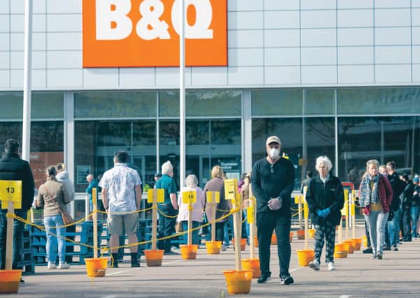 Members of the public follow social distancing guidelines and queue in the car park of B&Q. Picture PA
