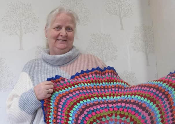 care home manager, Heather Allison, holding the prayerblanket staff crocheted