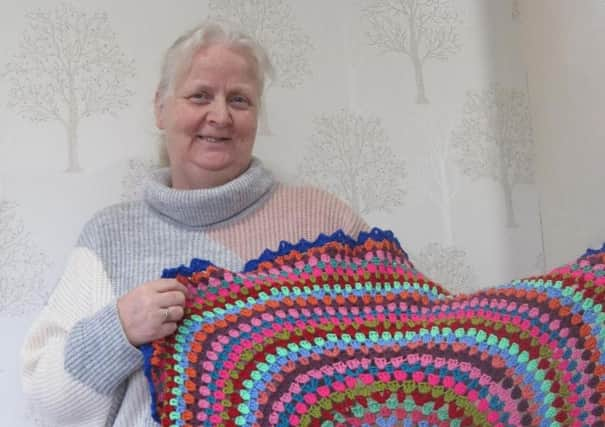 care home manager, Heather Allison, holding the prayer
blanket staff crocheted