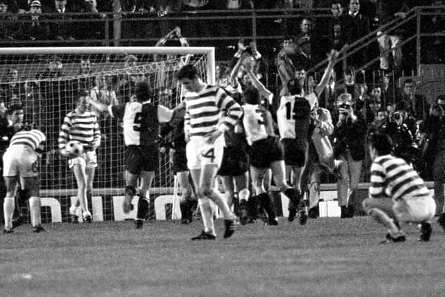 Dejected Celtic players look on as Feyenoord celebrate the winning goal in extra time