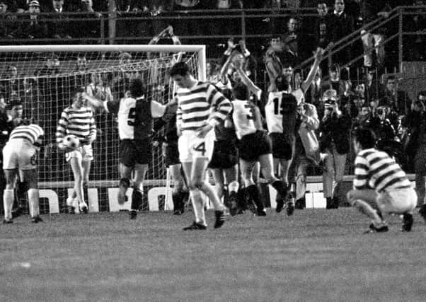 Dejected Celtic players look on as Feyenoord celebrate the winning goal in extra time