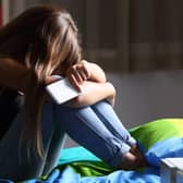 A Generic Photo of a teenage girl sitting on a bed holding a mobile phone, head in hands. See PA Feature FAMILY Expert Mental Health. Picture credit should read: thinkstock/PA. WARNING: This picture must only be used to accompany PA Feature FAMILY Expert Mental Health.