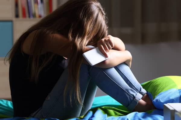 A Generic Photo of a teenage girl sitting on a bed holding a mobile phone, head in hands. See PA Feature FAMILY Expert Mental Health. Picture credit should read: thinkstock/PA. WARNING: This picture must only be used to accompany PA Feature FAMILY Expert Mental Health.