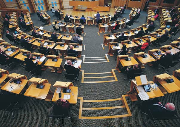 MSPs social distancing with every second seat removed.