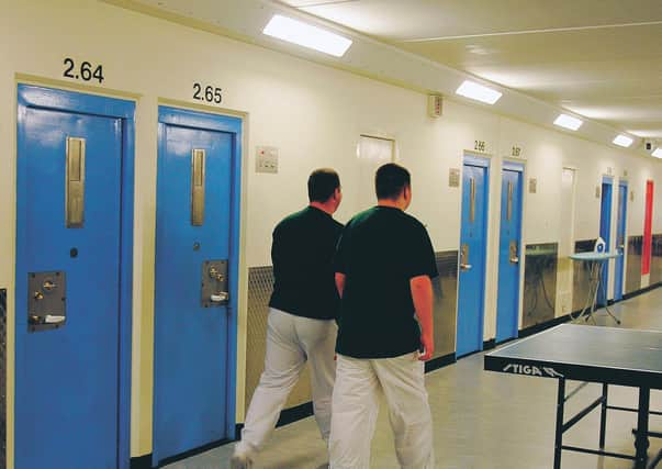 Two inmates walk along the corridor of Munro hall at HMYOI, Polmont.