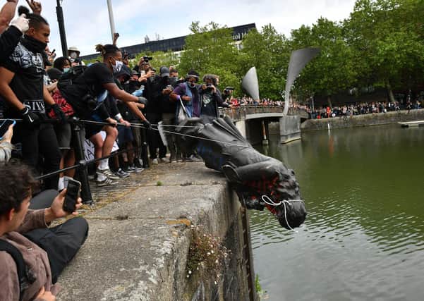 Protesters throw a statue of slave trader Edward Colston into Bristol harbour during a Black Lives Matter rally in memory of George Floyd (Picture: Ben Birchall/PA Wire)