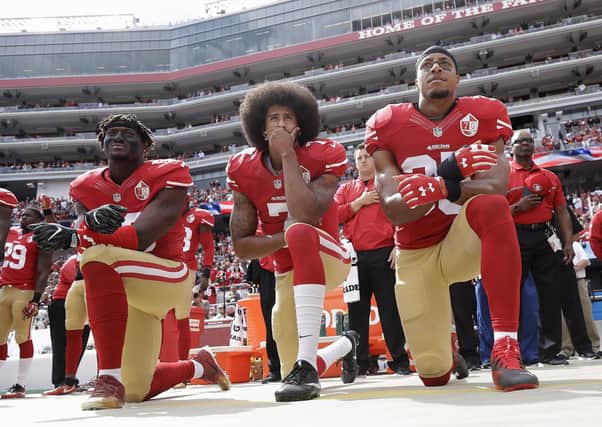 San Francisco 49ers trio Eli Harold, Colin Kaepernick and Eric Reid kneel during the national anthem. Picture: Marcio Jose Sanche/AP