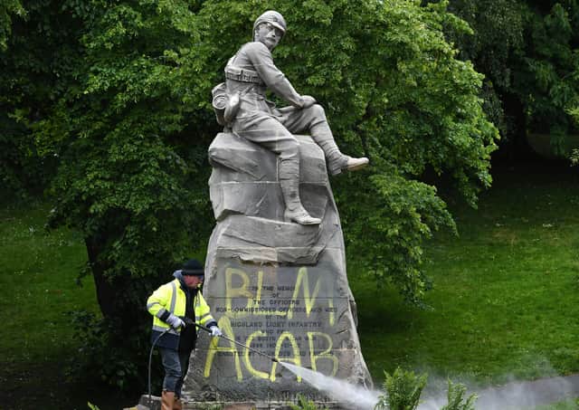 Council workers clean a war memorial commemorating the Second Boer War. Picture: John Devlin