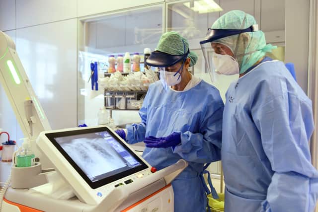 Medical staff wearing their personal protective equipment (PPE) look at a patient's scan. Picture: Piero Cruciatti/AFP via Getty Images