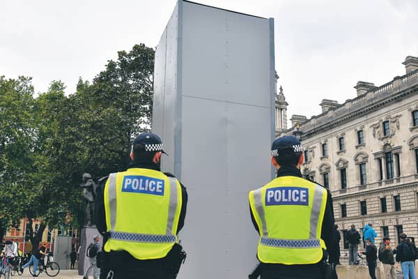 Police guard the boxed statue of Churchill in Parliament Square, London. Picture: Dominic Lipinski/PA