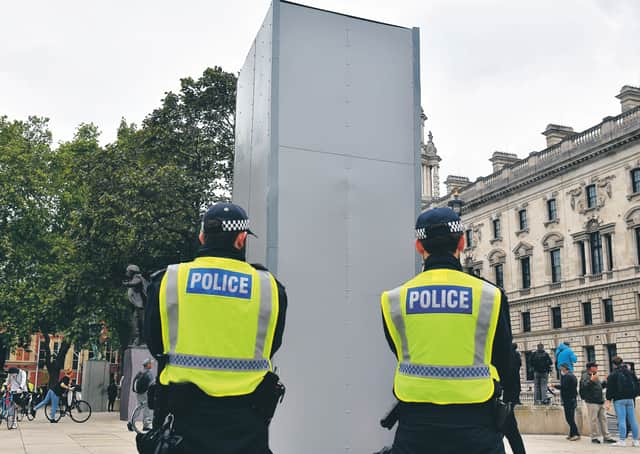 Police guard the boxed statue of Churchill in Parliament Square, London. Picture: Dominic Lipinski/PA