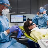 Dentist Fiez Mughal (left) and dental nurse Johanna Bartha (right) don their protective gloves and face shields. Picture: Leon Neal/Getty Images