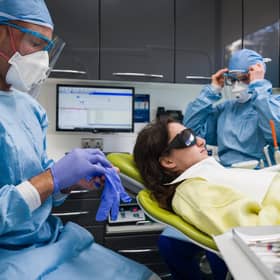 Dentist Fiez Mughal (left) and dental nurse Johanna Bartha (right) don their protective gloves and face shields. Picture: Leon Neal/Getty Images