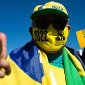 A supporter of Jair Bolsonaro wears a mask just like the controversial Brazilian President now does, after a judge ordered him to (Picture: Andressa Anholete/Getty Images)
