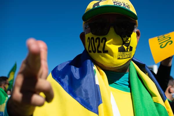 A supporter of Jair Bolsonaro wears a mask just like the controversial Brazilian President now does, after a judge ordered him to (Picture: Andressa Anholete/Getty Images)