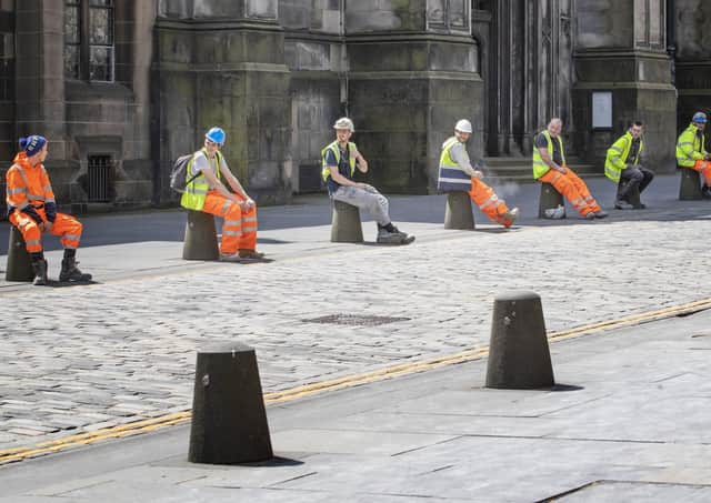 Construction workers comply with social distancing during their break along Edinburgh's Royal Mile