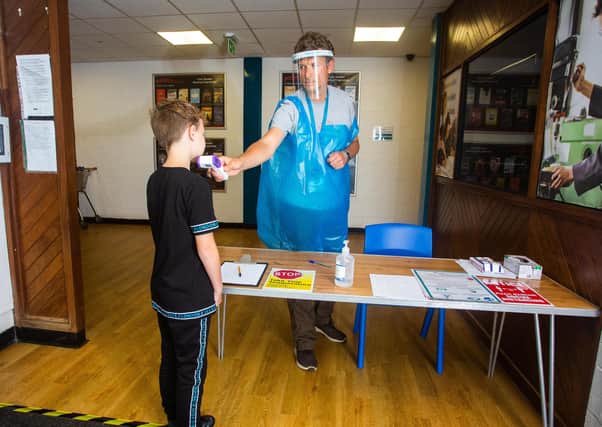 A year 7 pupil at the Lipson Co-operative Academy in Plymouth, Devon, has a temperature reading.