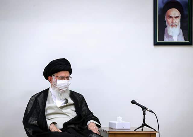 Iran’s Supreme Leader Ayatollah Ali Khamenei wears a coronavirus face mask while seated beneath a picture of his predecessor Ayatollah Ruhollah Khomeini (Picture: Khamenei.IR/AFP via Getty Images)
