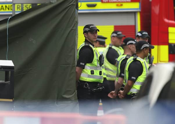 Police stand beside a bus stop covered by a tarpaulin in West George Street, Glasgow, where a man was shot by an armed officer (Picture: Andrew Milligan/PA Wire)