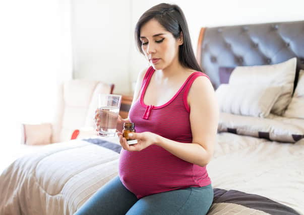 A woman taking medicine during pregnancy