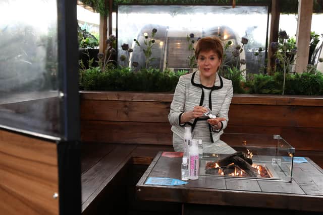 First Minister Nicola Sturgeon sits by a fire pit table during a visit to Cold Town House in Edinburgh's Grassmarket. Picture: Andrew Milligan - Pool/Getty Images