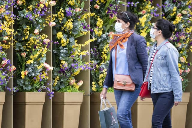 Shoppers wear protective face masks in Edinburgh's Princes Street to avoid the spread of coronavirus. Scientists have linked Covid-19 to a rare form of brain inflammation. Picture: Jane Barlow/PA Wire