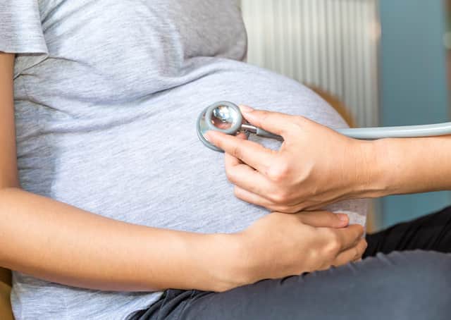 A doctor examines a pregnant woman