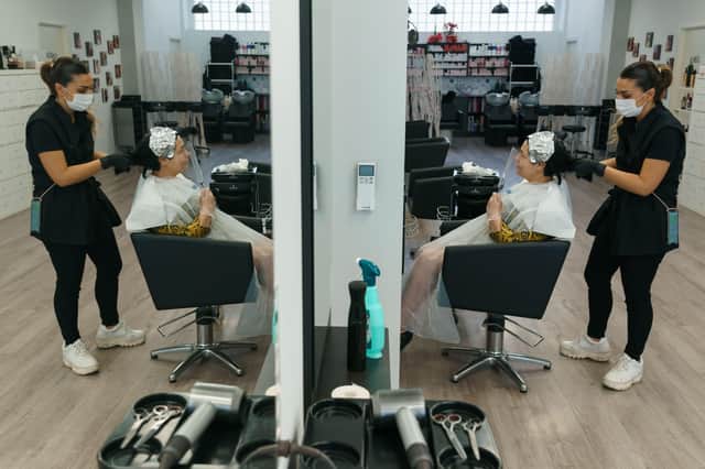 Spanish hairdresser Virginia attends her first client after reopening her salon in Burgos, on May 4, 2020, for the first time since the beginning of a national lockdown to prevent the spread of the COVID-19 disease. - Masks became mandatory on public transport today as Spain took its first tentative steps towards a commercial reopening with small businesses accepting customers by appointment and restaurants prepping food for takeaway. Spain's population of nearly 47 million people have been confined to their homes for more than 50 days as the country sought to curb the spread of the deadly virus which has so far claimed 25,428 lives. (Photo by CESAR MANSO / AFP) (Photo by CESAR MANSO/AFP via Getty Images)