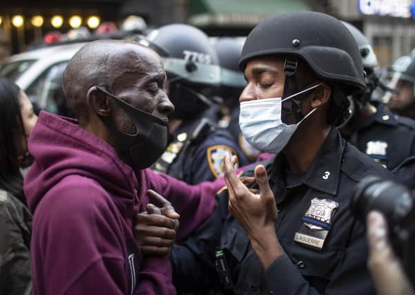 A protester and a police officer shake hands during a stand-off in New York – but not all US police are as empathetic (Picture: Wong Maye-E/AP)