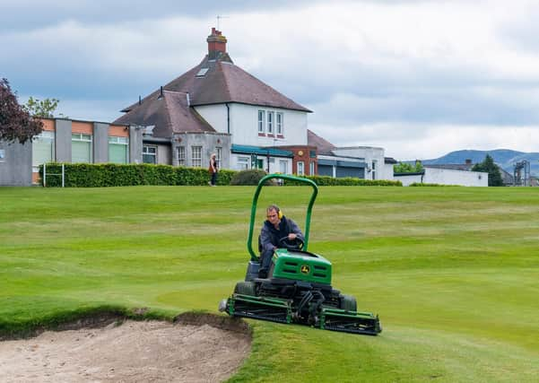 A groundsman at Carrick Knowe gets the course ready for reopening. Picture: SNS.