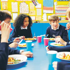 Pupils eating school meals and talking