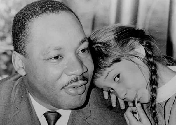 Six-year-old Robin Arrington leans on Dr Martin Luther King’s shoulder as he holds a press conference in Miami in 1966 (Picture: AP)