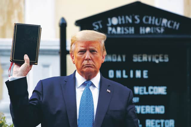 President Donald Trump holds a Bible as he visits St John's Church across Lafayette Park from the White House. Part of the church was set on fire during protests. Picture: AP Photo/Patrick Semansky