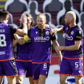 Dundee United players congratulate Mark Reynolds after the defender scored the only goal of the game at Fir Park. Picture: Steve Welsh/PA