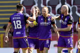 Dundee United players congratulate Mark Reynolds after the defender scored the only goal of the game at Fir Park. Picture: Steve Welsh/PA