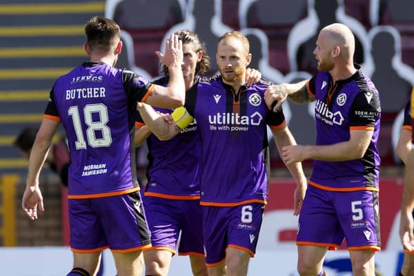 Dundee United players congratulate Mark Reynolds after the defender scored the only goal of the game at Fir Park. Picture: Steve Welsh/PA