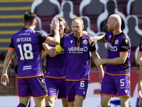 Dundee United players congratulate Mark Reynolds after the defender scored the only goal of the game at Fir Park. Picture: Steve Welsh/PA