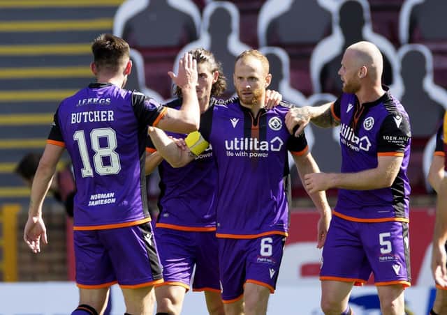 Dundee United players congratulate Mark Reynolds after the defender scored the only goal of the game at Fir Park. Picture: Steve Welsh/PA
